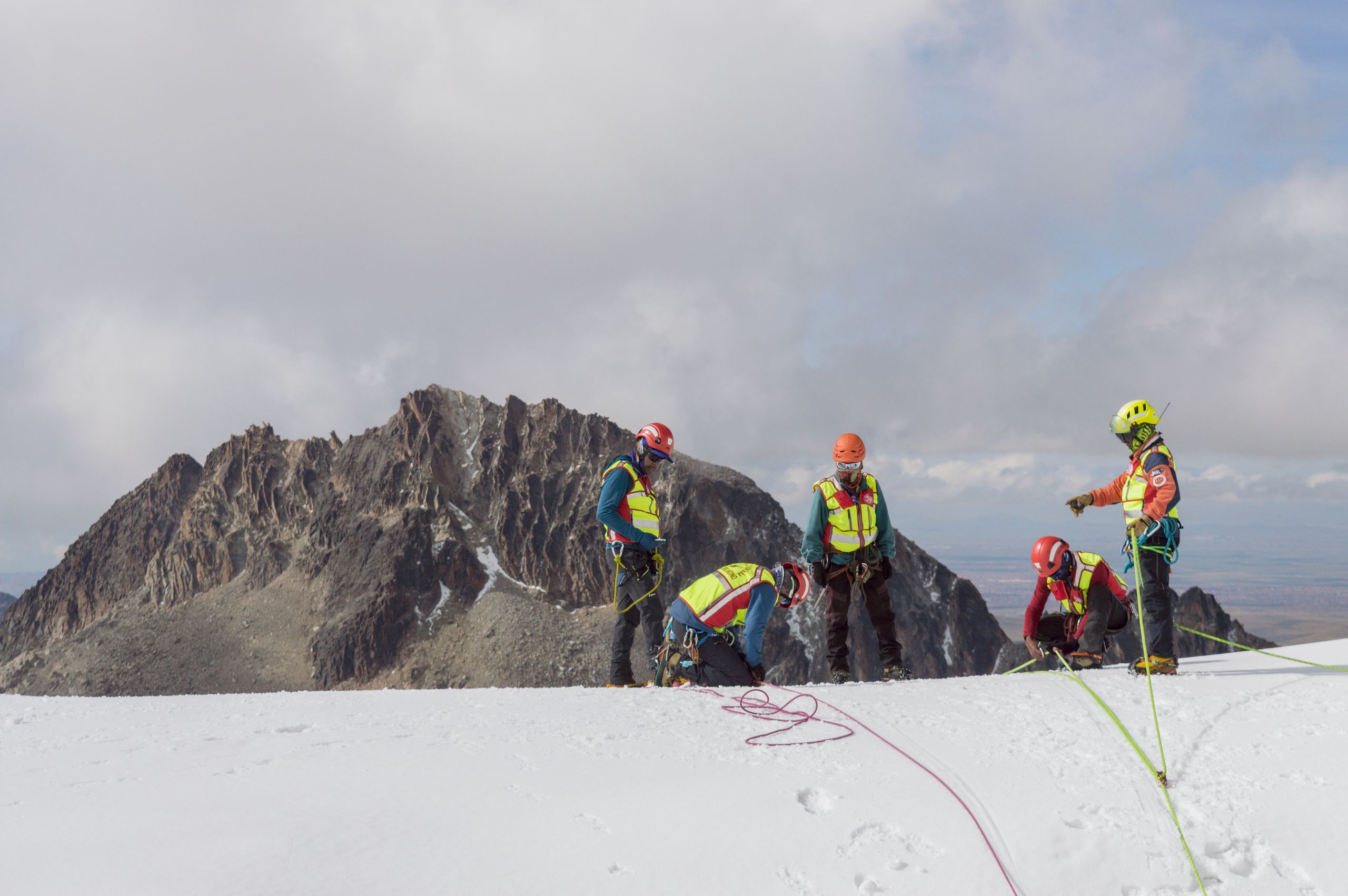 A group of climbers in safety gear conducting a winter mountain expedition.