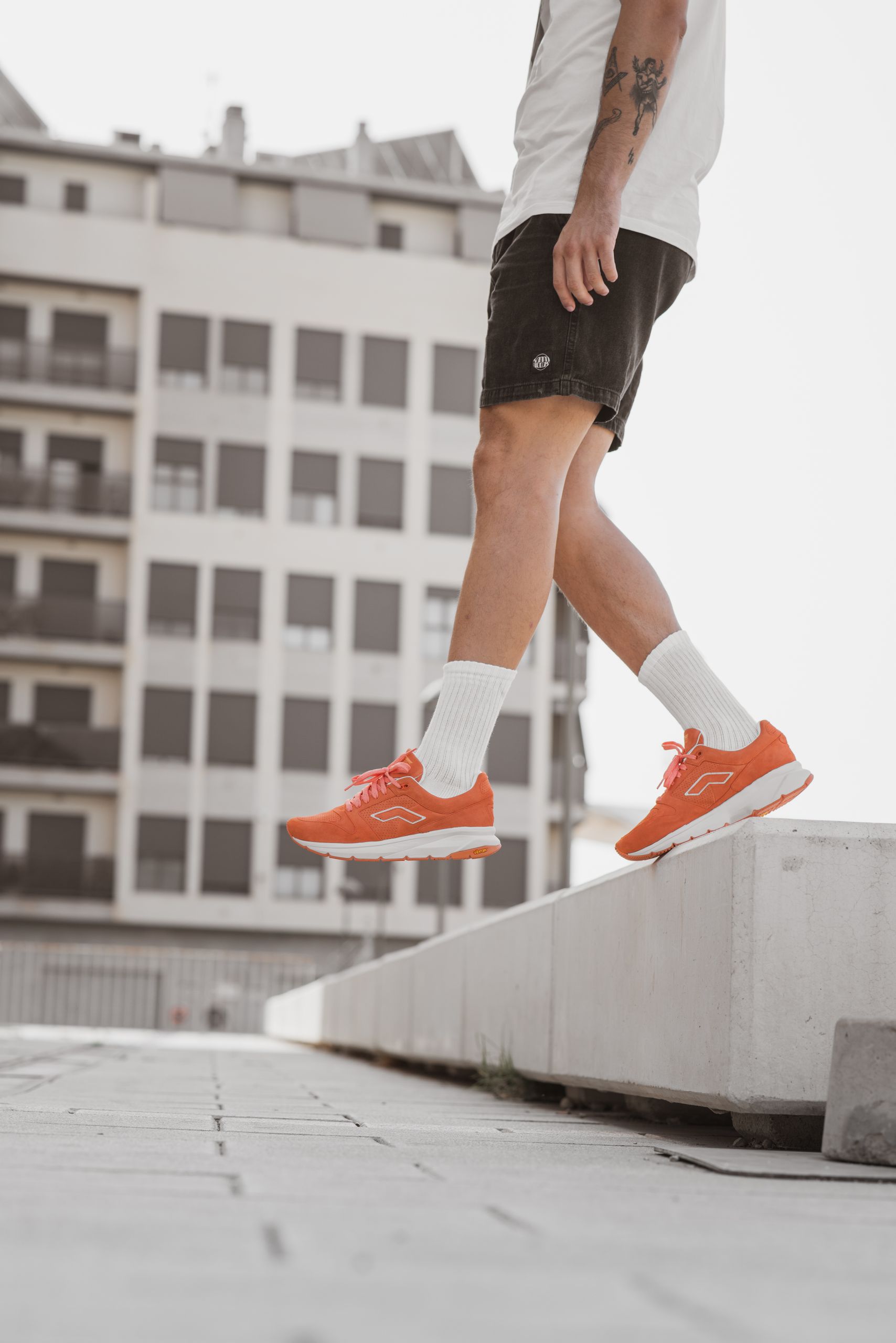 Close-up of a person wearing orange sneakers, showcasing urban style and dynamic fashion.
