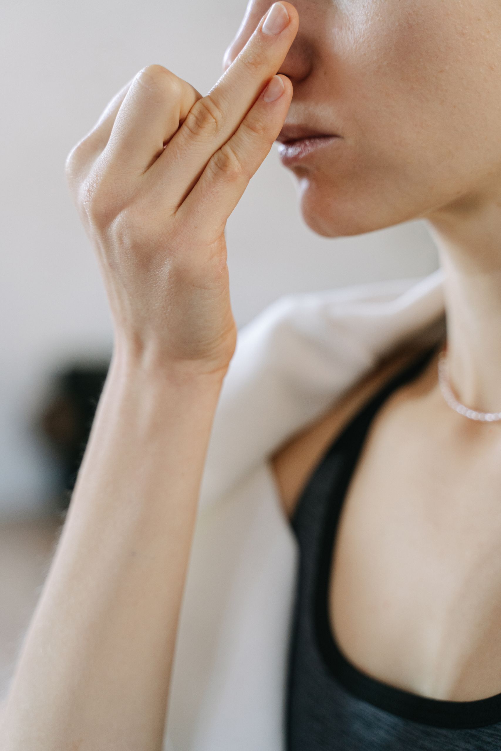 Focused close-up of a woman practicing yoga breathing exercise with fingers in a specific mudra.