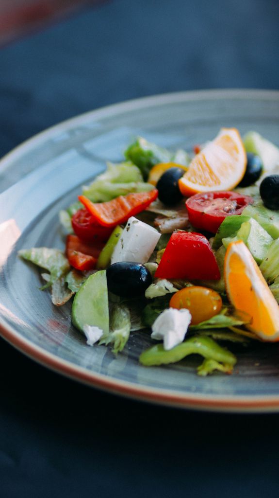 Nutritious salad made of various tasty vegetables and fruits placed on table in cafe