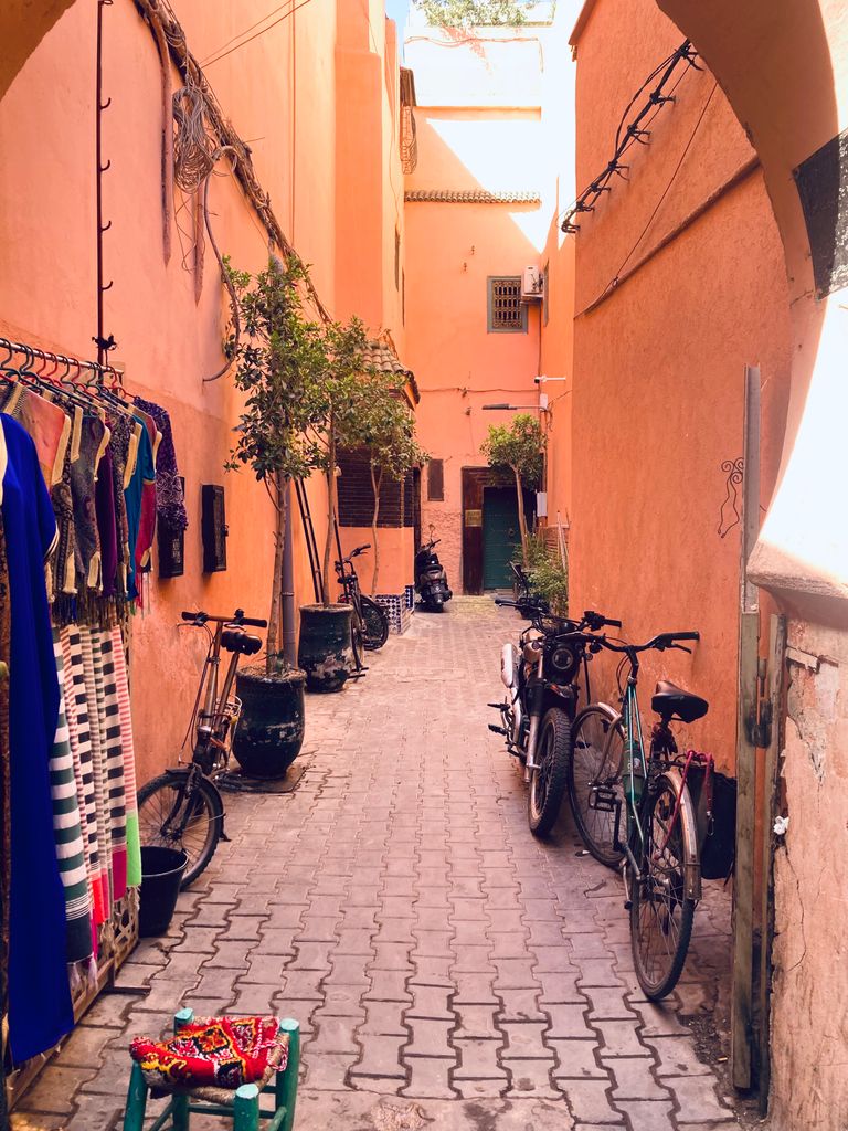 Picturesque alleyway with bicycles and colorful textiles in Marrakech.