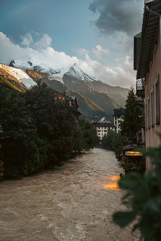 Scenic view of Chamonix town with Mont Blanc and flowing river in the French Alps.