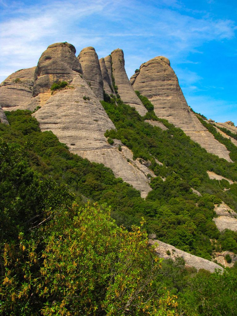 The majestic rock formations of Montserrat in Catalonia, Spain, against a vibrant blue sky.